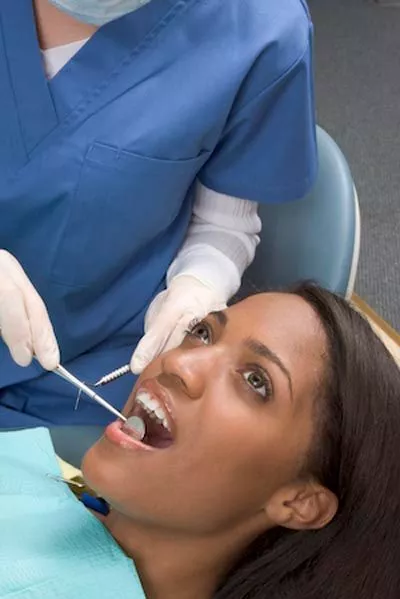 dentist checking on a patient's mouth after an oral surgery procedure
