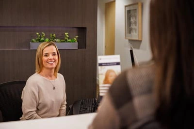 front office staff with dental savings plan brochure for patient