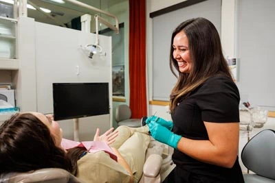 dental hygienist talking to a new patient in the chair